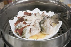 將鱸魚成花狀擺好，將火腿切片放入各縫隙中，放入鍋中隔水蒸12分鐘拿出，撒上蔥花即可。