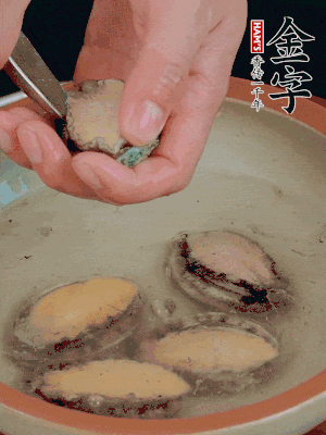 鮑魚加鹽、清水浸泡，用勺子挖出鮑魚肉。