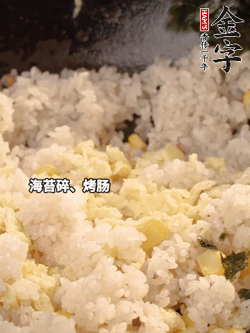 剩米飯下鍋炒散，依次下玉米粒、雞蛋、烤腸、海苔碎翻炒均勻。