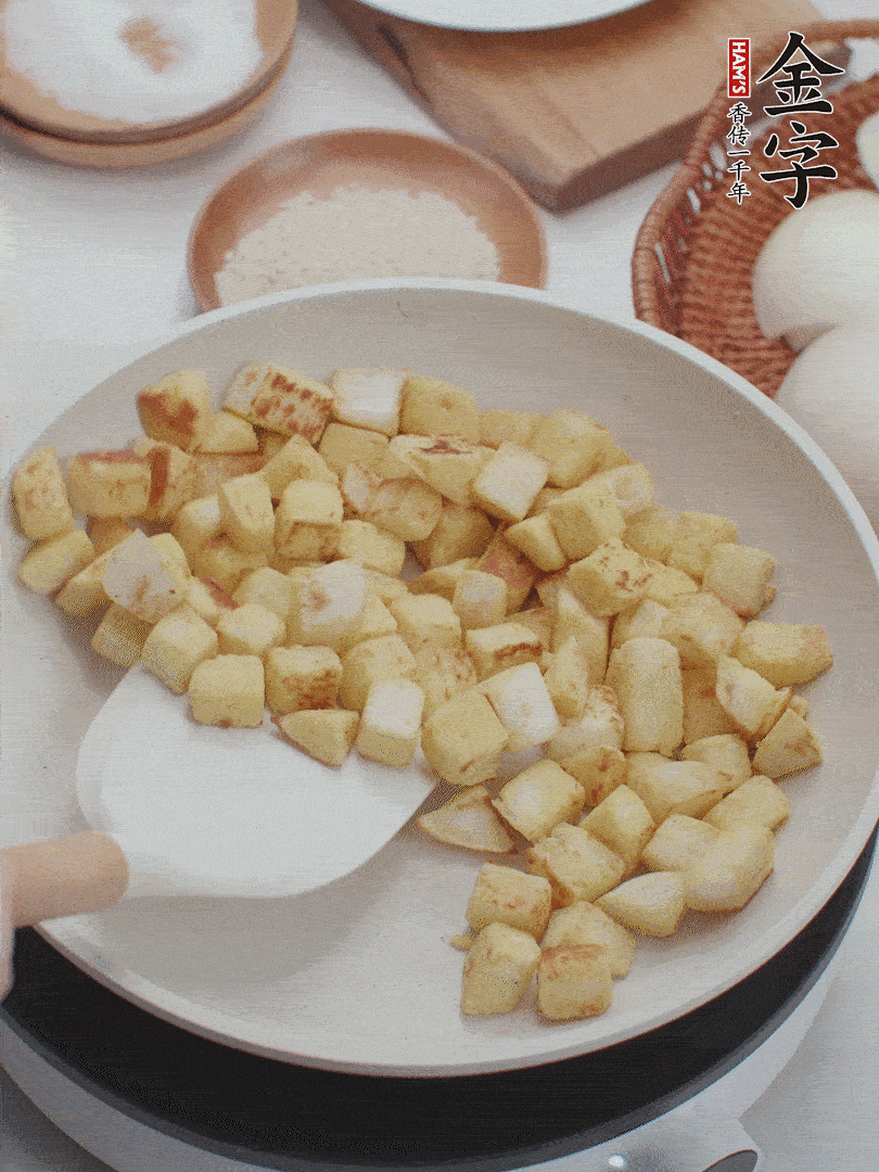 起鍋熱油，倒入饅頭丁，小火煎至蛋液凝固定型再翻面，饅頭丁部煎至金黃時盛起待用。