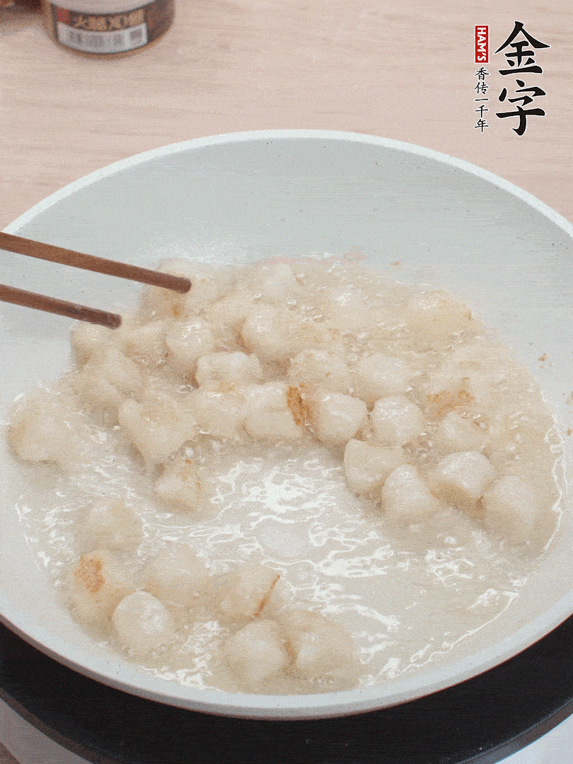 油溫4成熱，鮮貝蘸干淀粉下鍋煎，一面微黃后翻面。