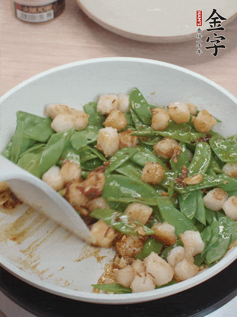 下甜豆莢、鮮貝輕輕翻炒均勻。