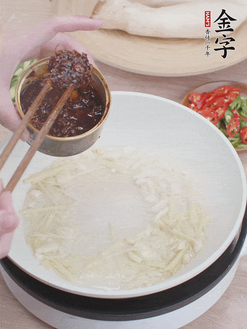 起鍋熱油，姜蒜、金字火腿干貝醬煸香。