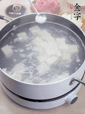 豆腐切成大小均勻正方體，鍋內(nèi)放水，加一點鹽焯水10秒。