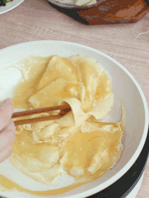 油6成熱時(shí)，下雞蛋液，邊緣凝固時(shí)翻拌成塊狀。