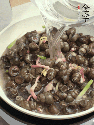 倒處理干凈的螺螄翻炒，加3勺料酒。加清水蓋過螺螄，中火蓋蓋煮5分鐘。