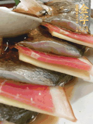 魚肚中塞蔥結、火腿片，魚身上碼放姜片、火腿片，倒入混合的料汁。