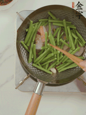 下掰好的缸豆段翻炒，略燜煮。
