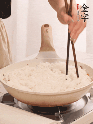 把瀝干水分的米飯均勻鋪在上面，筷子戳幾個洞，以便透氣，轉(zhuǎn)小火蓋上蓋子燜至水分收干，大概10分鐘。