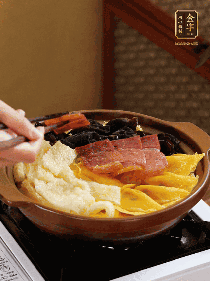 砂鍋底部鋪上娃娃菜，依次擺上肉皮、蛋餃、黑木耳、火腿