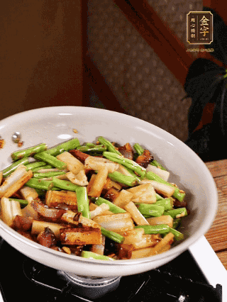 油熱下蒜末、干辣椒、醬肉煸炒出香味，依次下藕條、豆角翻炒均勻